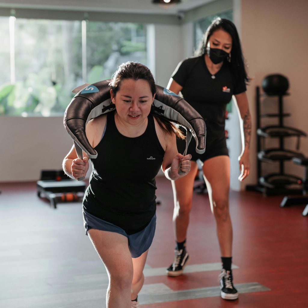A woman in the gym with her personal trainer.