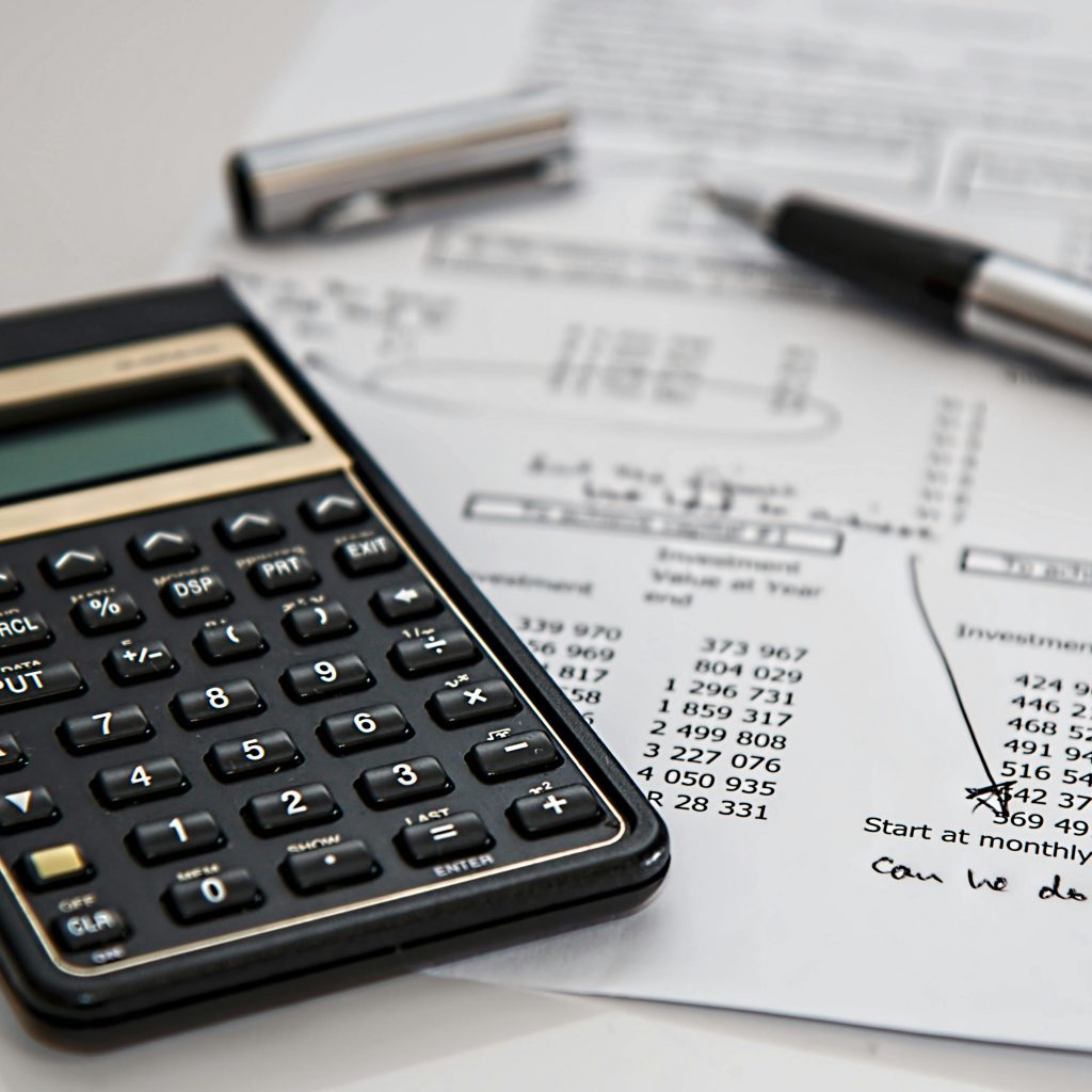 calculator, pen, and a written budget